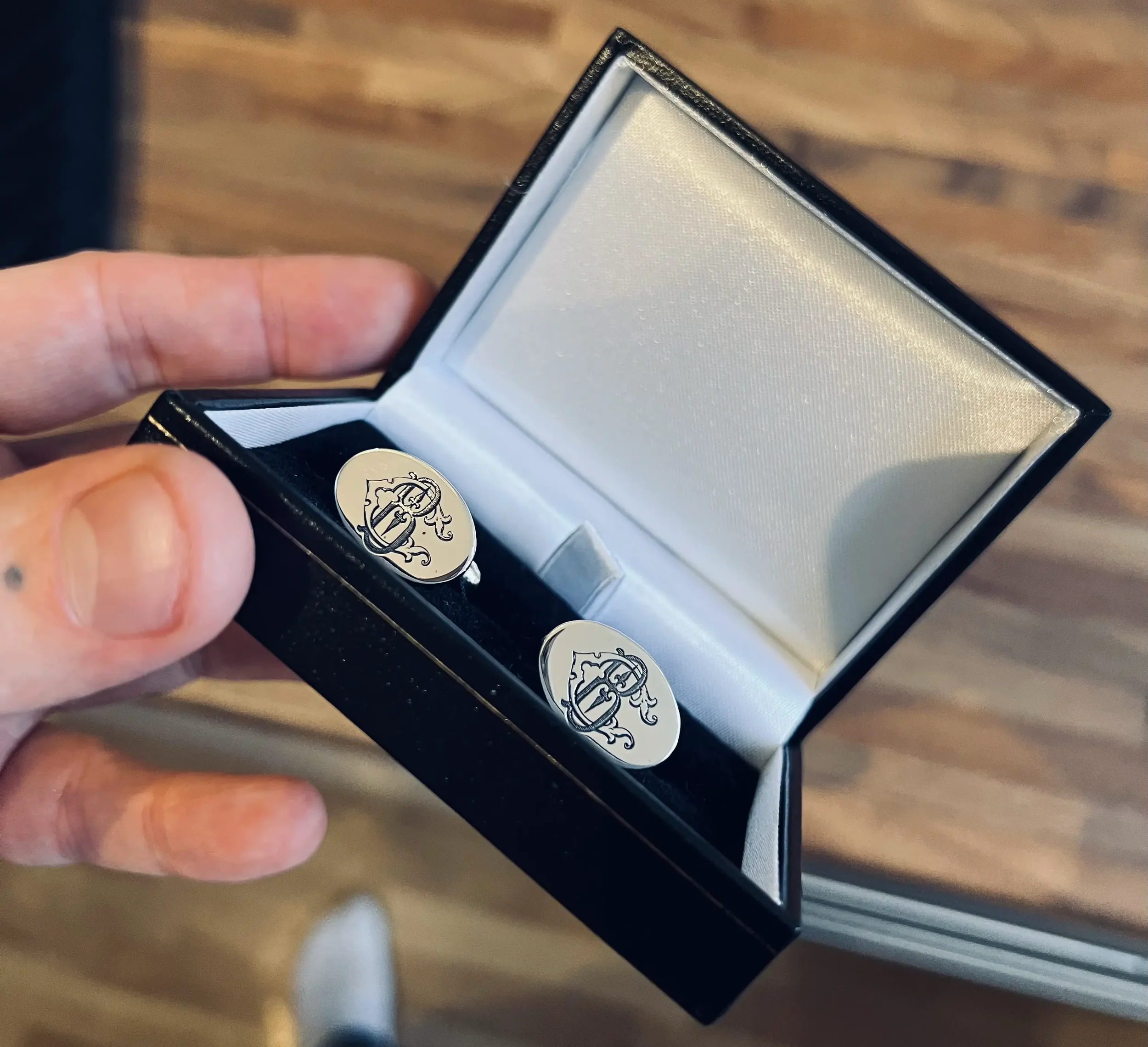 A pair of sterling silver cufflinks laser engraved with a monogram of the initials 'C' and 'B'.