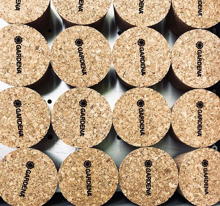 A group of cylindrical cork stoppers with the brand name 'GARDENIA' engraved on the top in black, arranged in a grid pattern.