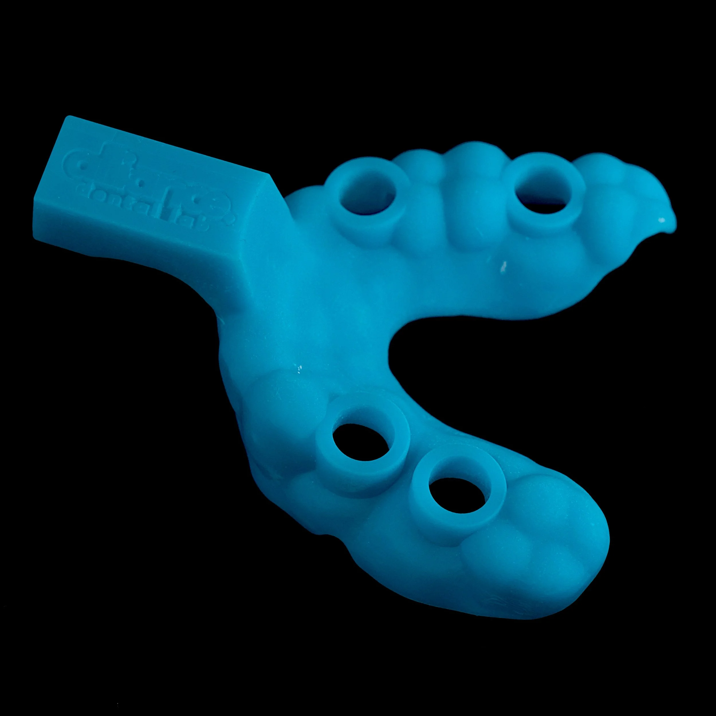 Light blue plastic toy shaped like a dinosaur, with several circular holes in its body, set against a black background.
