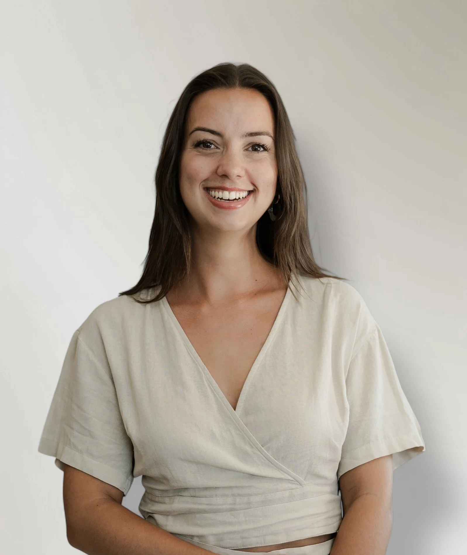 Alyssa Heurkens met donker haar in lichtgekleurde blouse, lachend in een interieur.