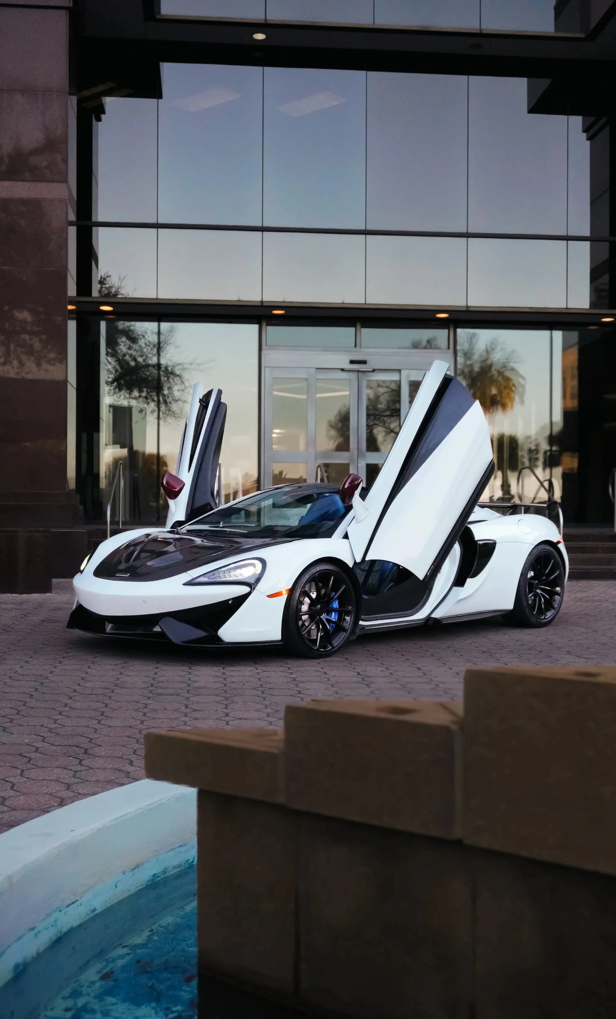 White McLaren 570S Spyder with doors open in Tampa luxury car rental