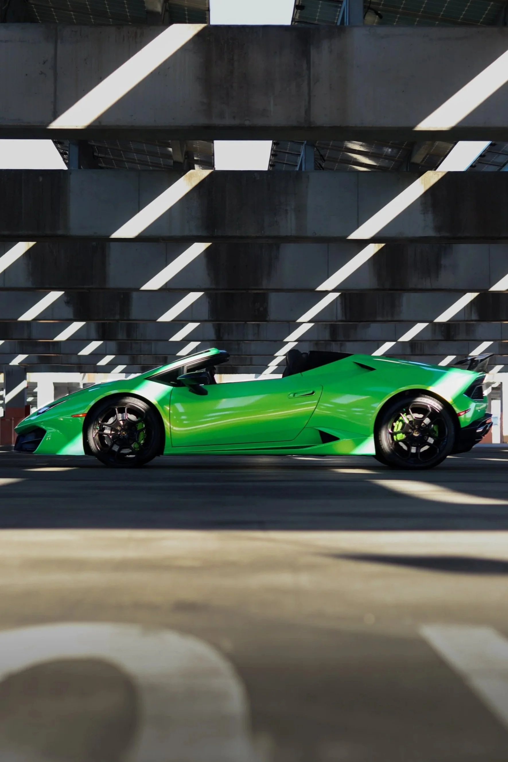 Green 2019 Lamborghini Huracan Spyder side profile, luxury convertible rental in Tampa Bay.