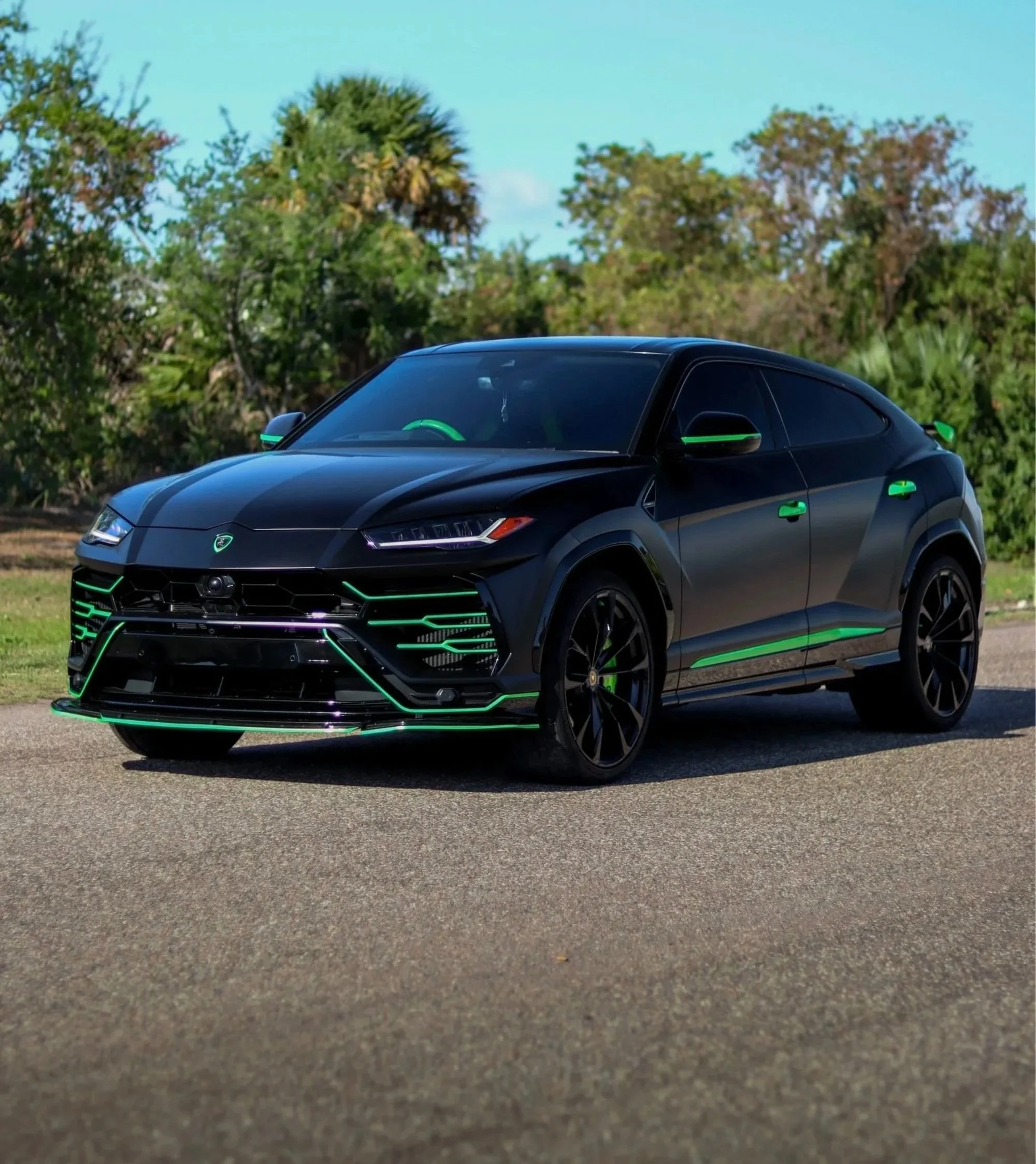 Black Lamborghini Urus with green accents parked on a road in Tampa available for exotic SUV rental from SteerForce Rentals