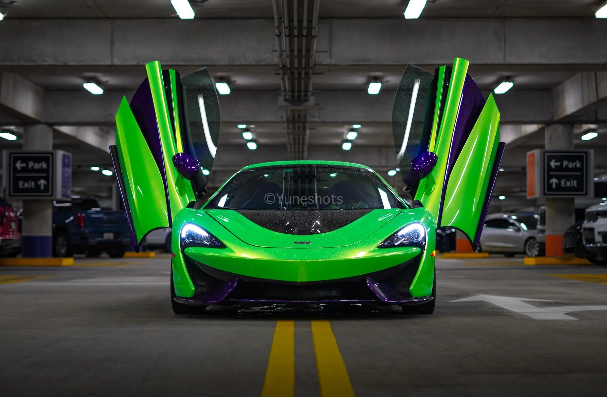 Front view of the custom green 2020 McLaren 570S Spyder with dihedral doors open, available for exotic car rental in Tampa, Florida.