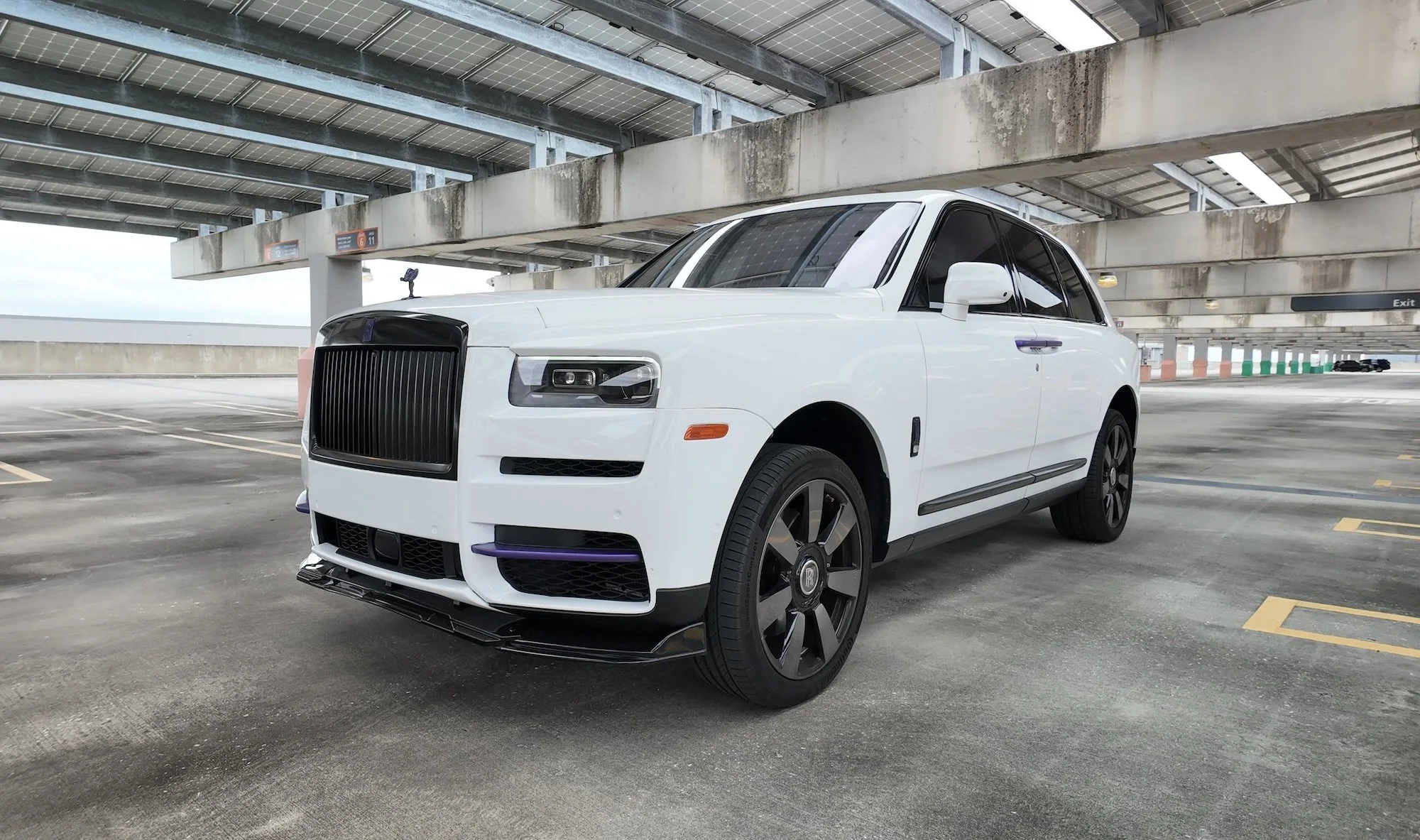 2023 Rolls Royce Cullinan rental in Tampa with white exterior, black grille, and custom purple accents