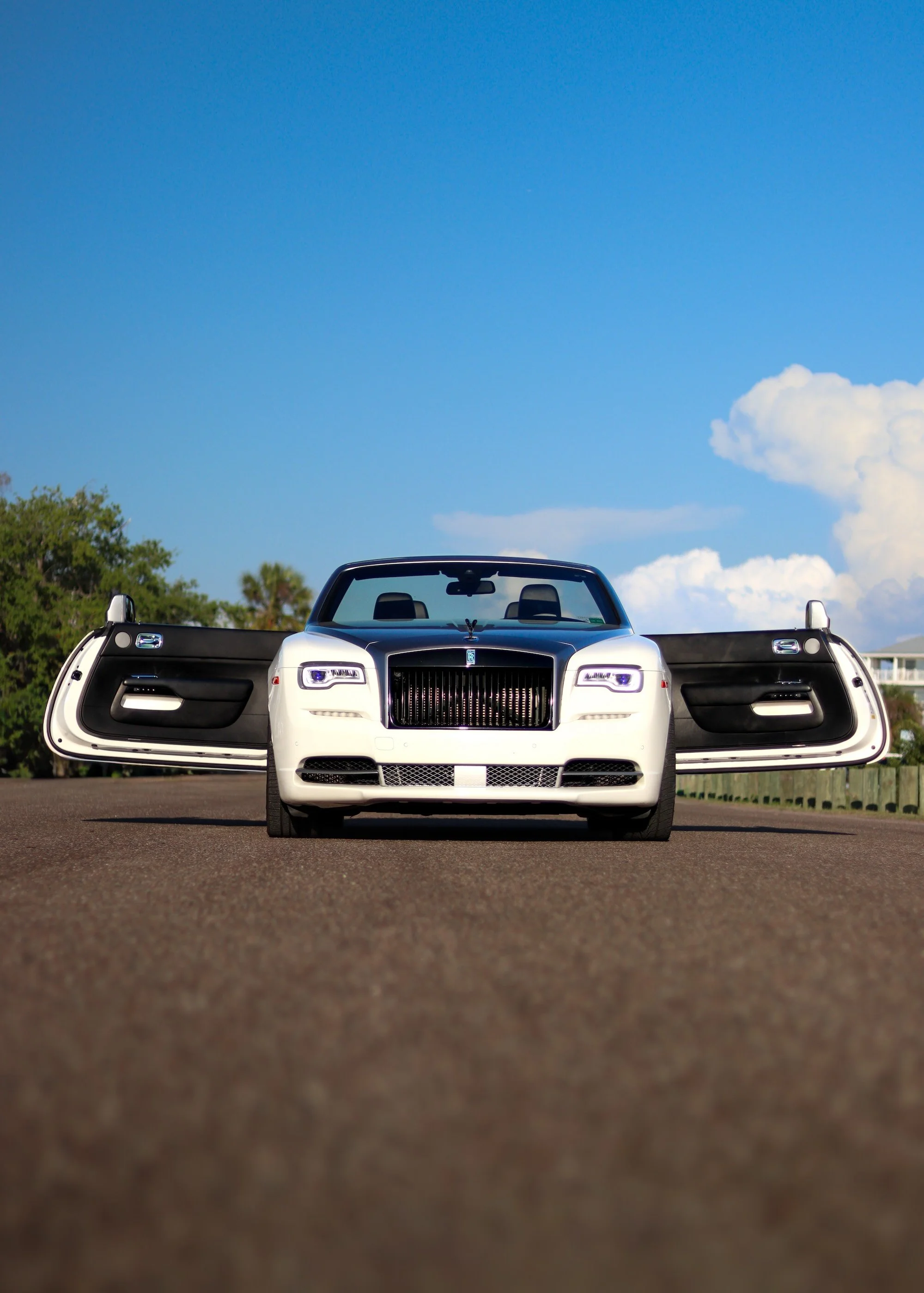 White Rolls-Royce Dawn convertible with doors open in Tampa luxury car rental