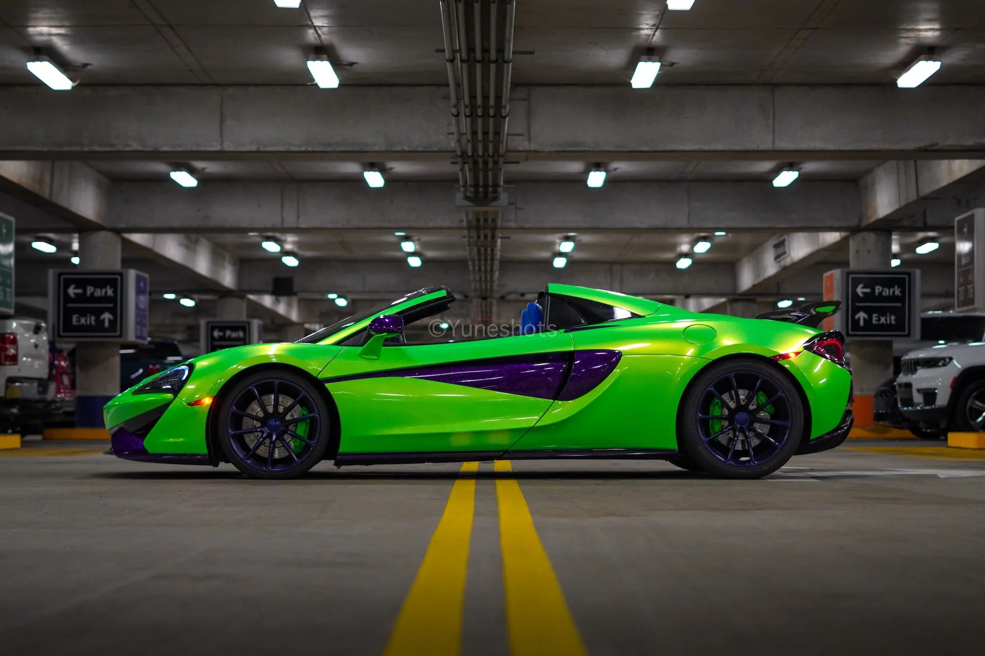 Side profile of the custom green 2020 McLaren 570S Spyder with purple forged carbon fiber accents, available for luxury car rental in Tampa and Clearwater.