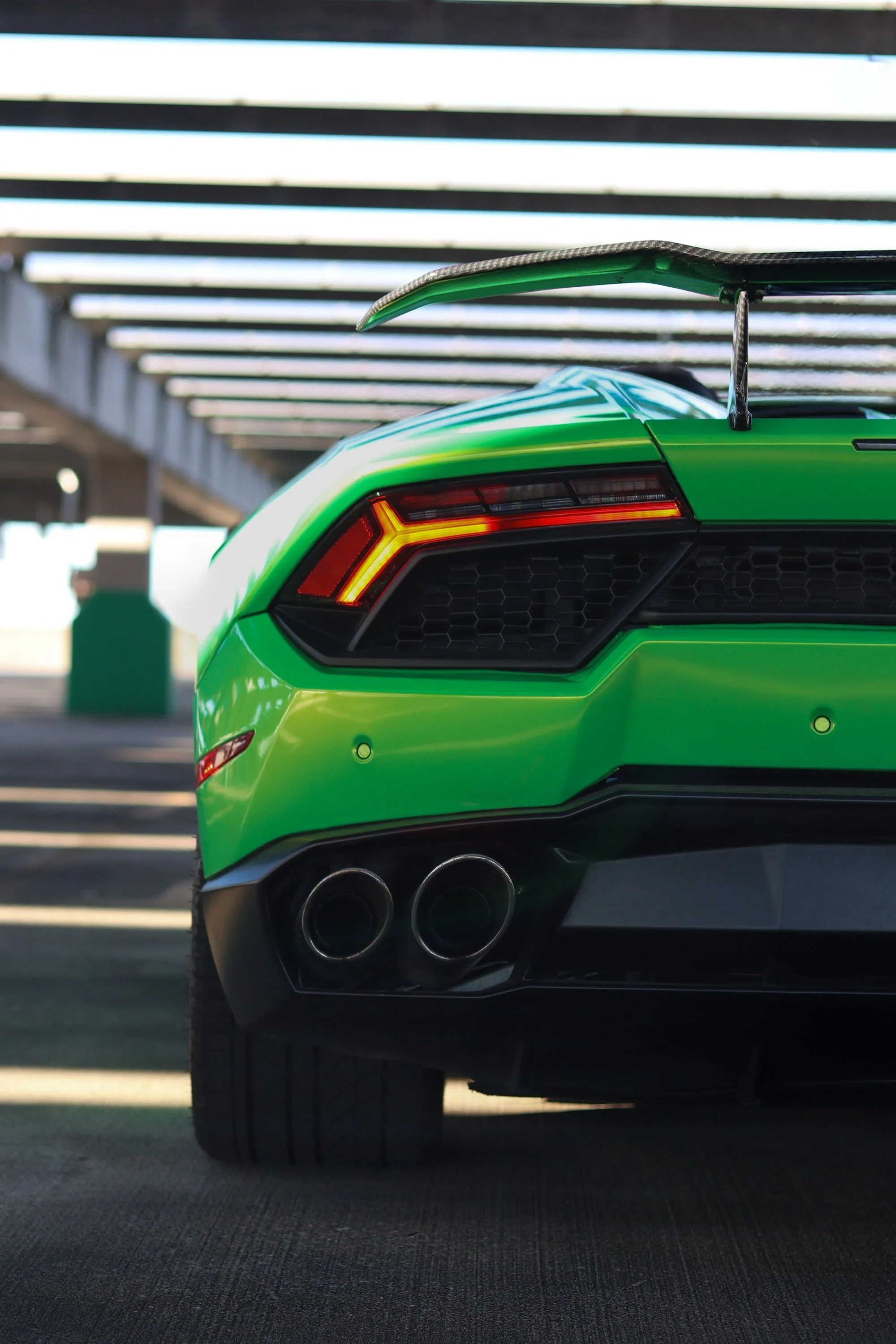 Rear view of green 2019 Lamborghini Huracan Spyder rental in Tampa showing LED taillights and dual exhaust.