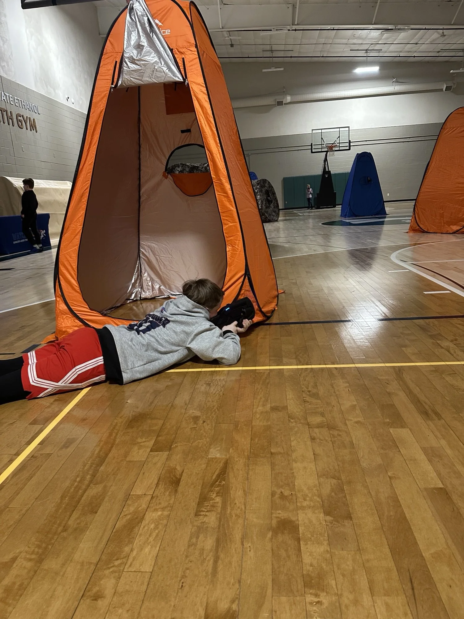 kid-aiming-laser-tagger-behind-tent-school-family-night.jpg