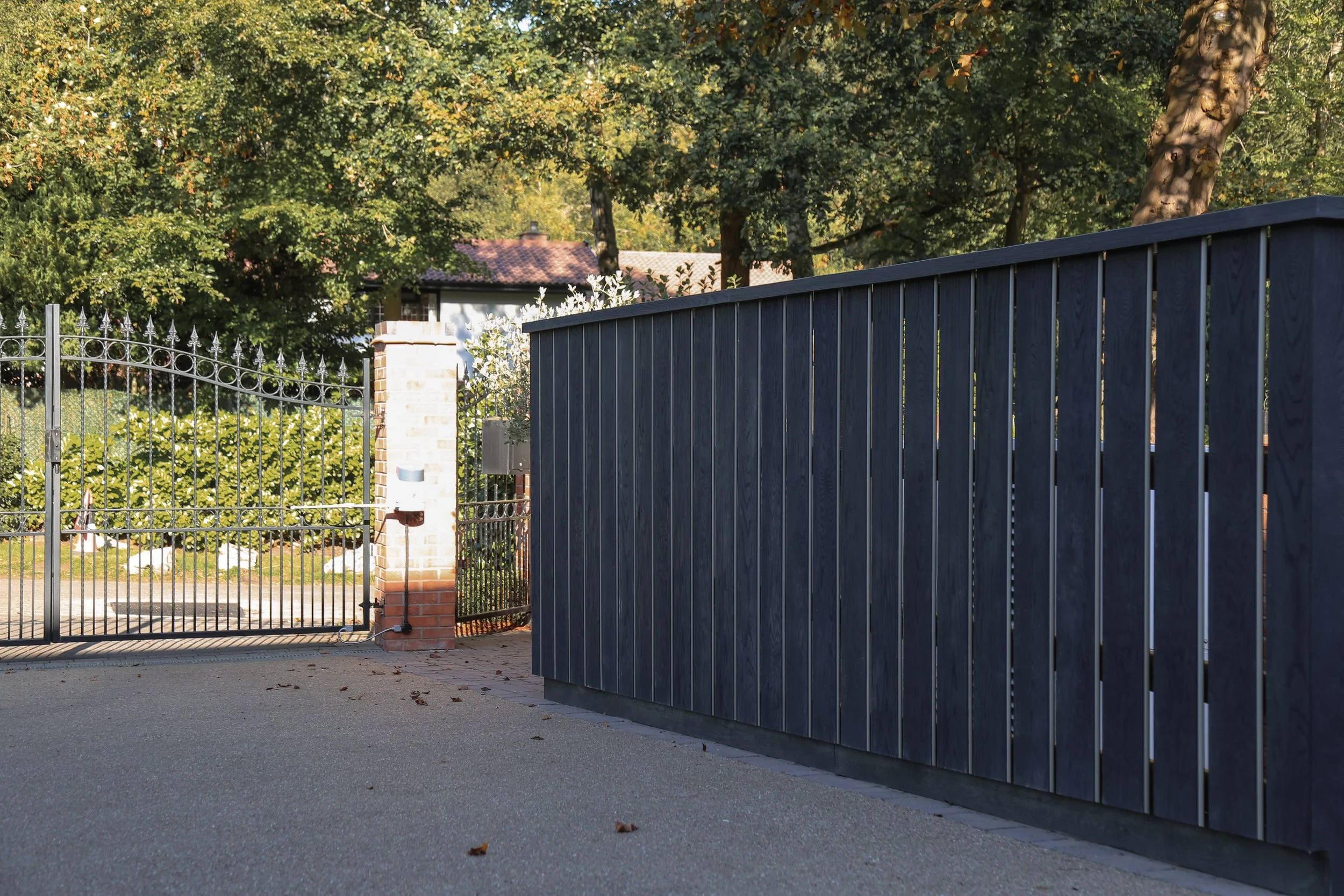 Bespoke fencing made from composite materials, next to a self binding gravel driveway and natural stone cobbled boarders