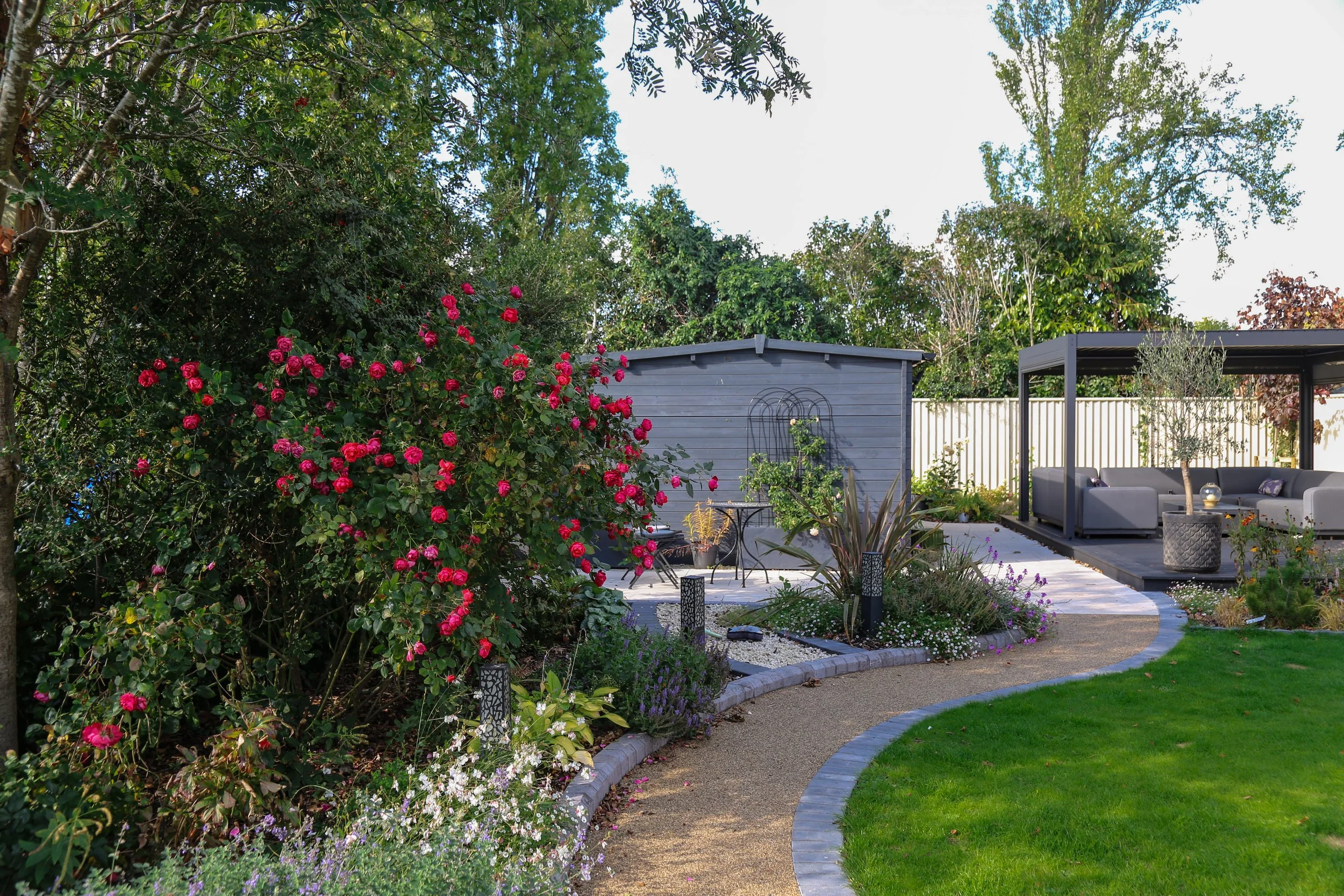 Full garden transformation, with an aluminium pergola, self binding gravel, and a composite deck, lots of porcelain paving installed