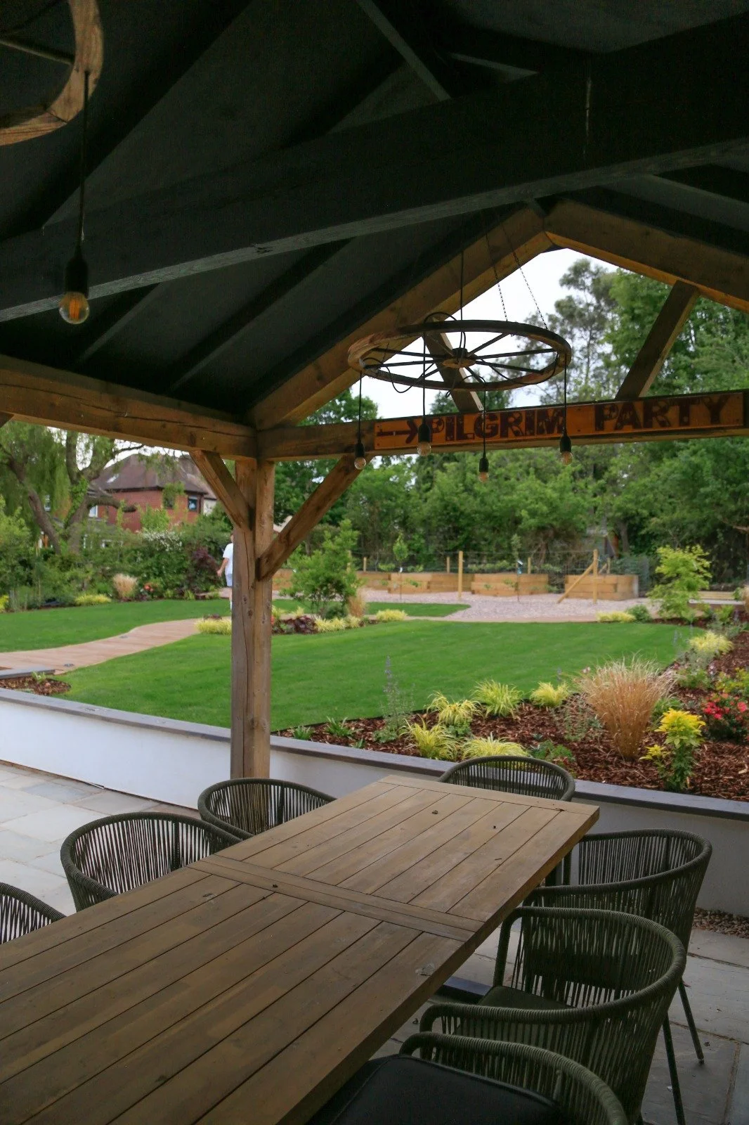 Covered outdoor eating area in Warwickshire, with views of the garden and the planting beds.