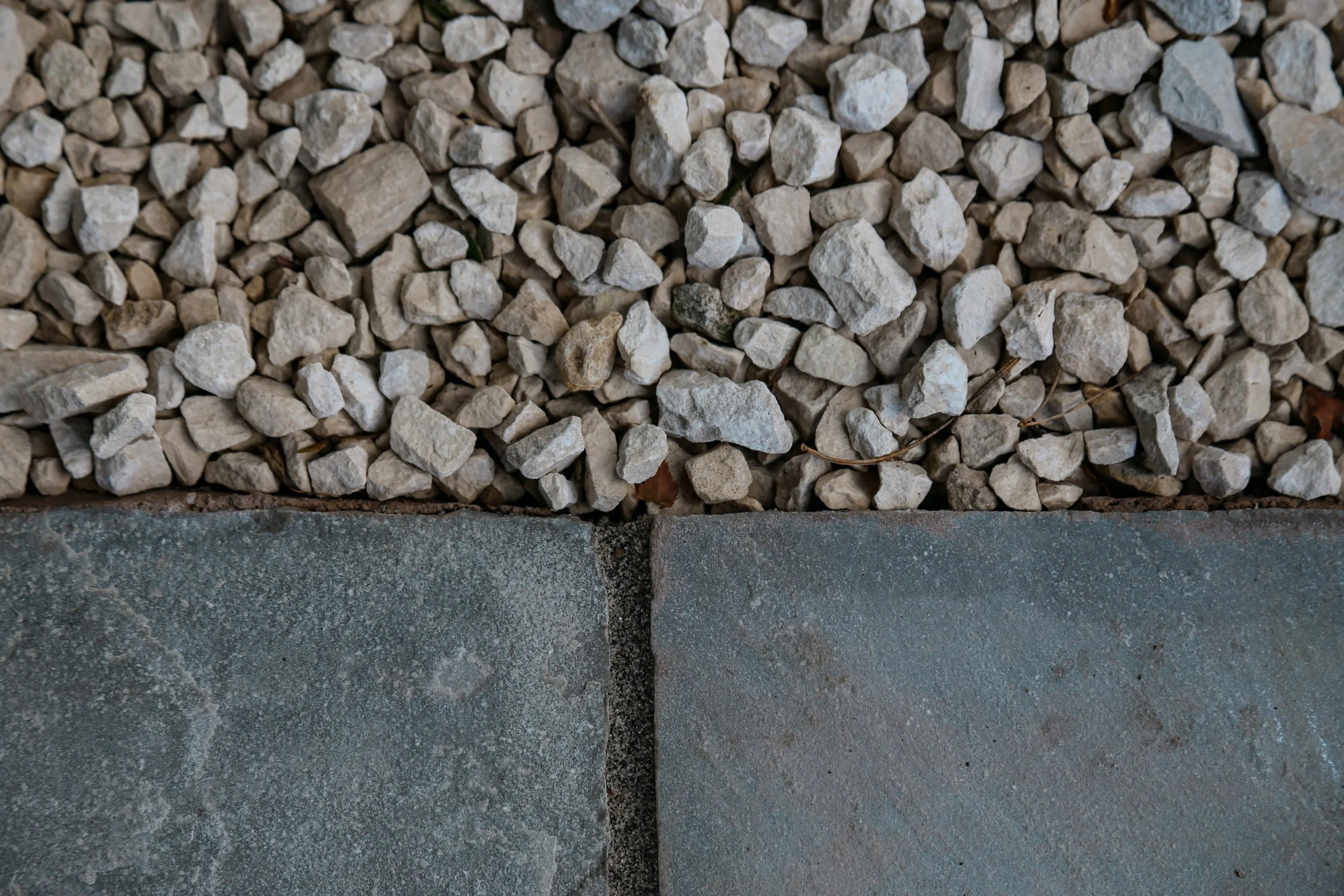 Natural stone paving, sitting next to cream coloured gravel,