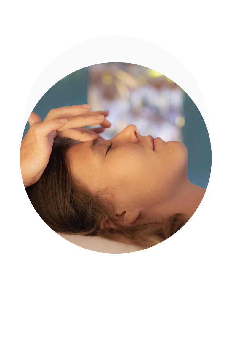 tête de femme couchée sur une table de massage avec des mains aposées sur son front dans un médaillon rond