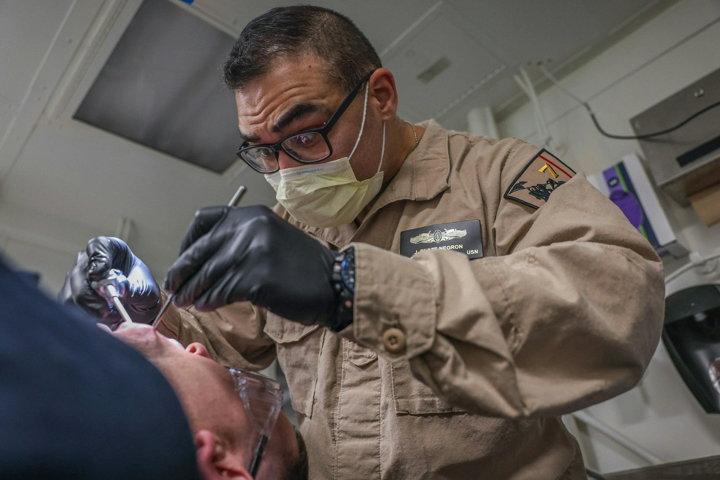 Military medical professional conducting a clinical evaluation as part of the medical waiver assessment for Service Academy and ROTC applicants.