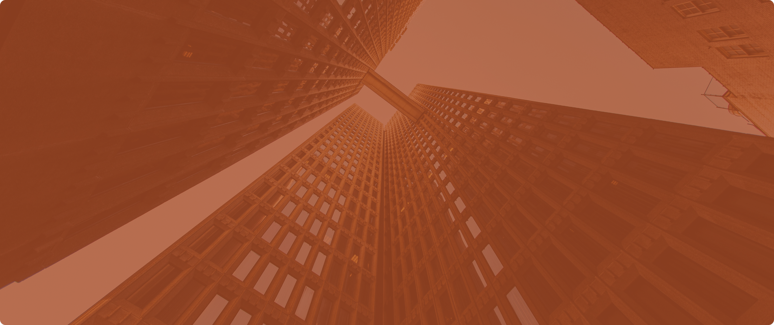 Low-angle view of tall buildings with an orange tint.