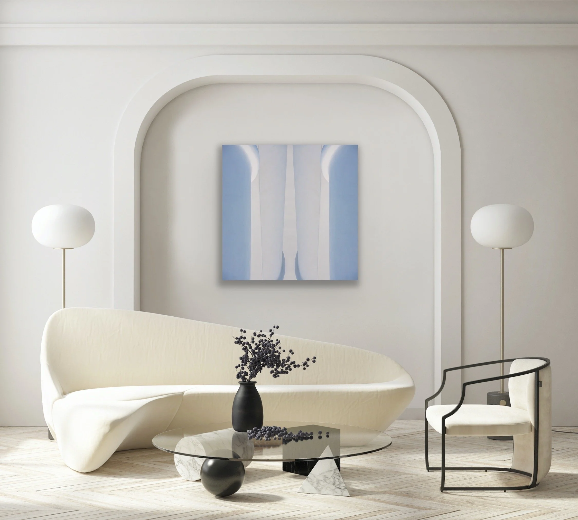 Modern minimalist living room with white curved sofa, black and white marble coffee table, cream armchair with black frame, two white side lamps, and abstract artwork on white wall.