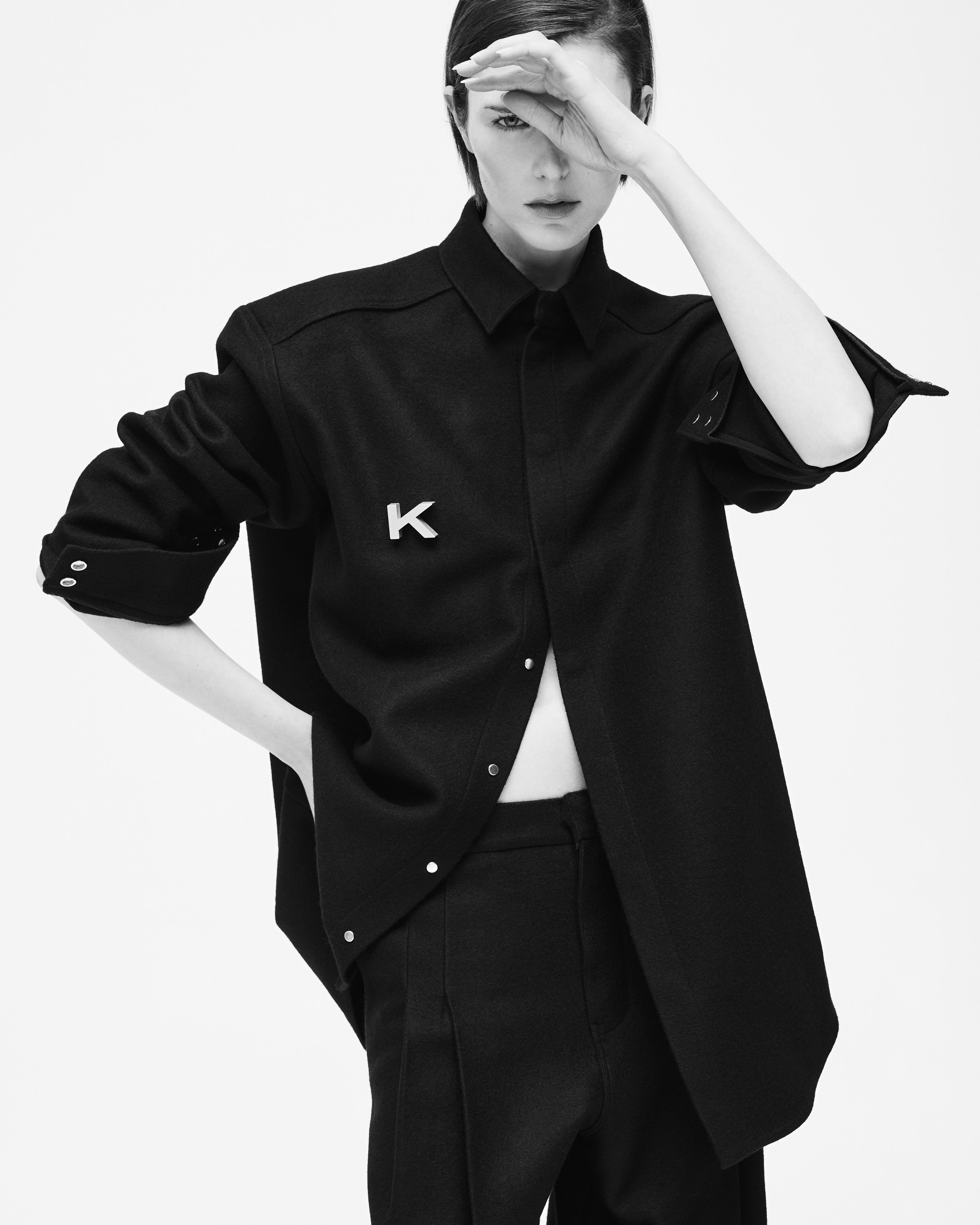 Schwarz-weiß-Foto einer Frau in schwarzer Kleidung, die eine Hand über die Stirn hält.