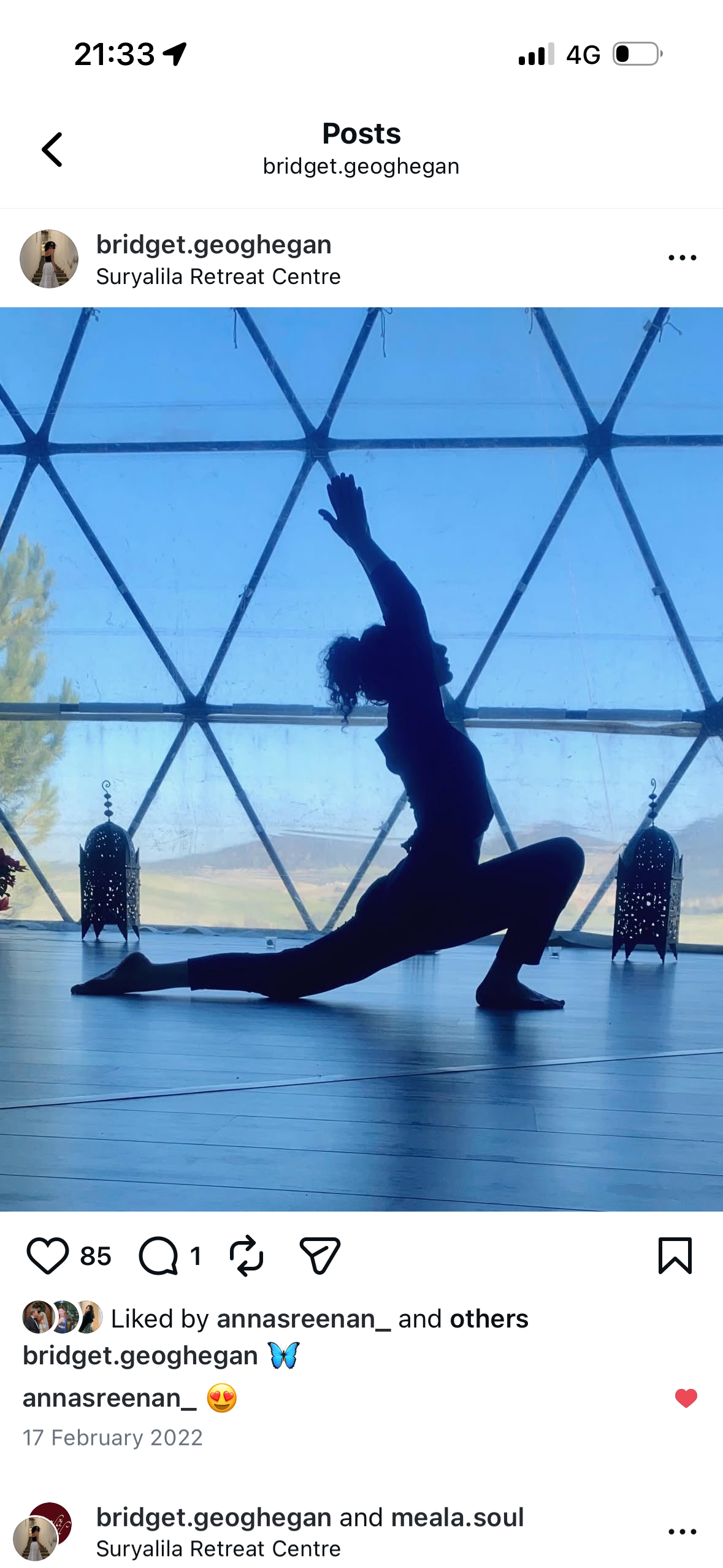 Silhouette of a woman performing a yoga pose indoors with a geodesic dome window in the background, showing trees and sky outside, at Suryalila Retreat Centre.