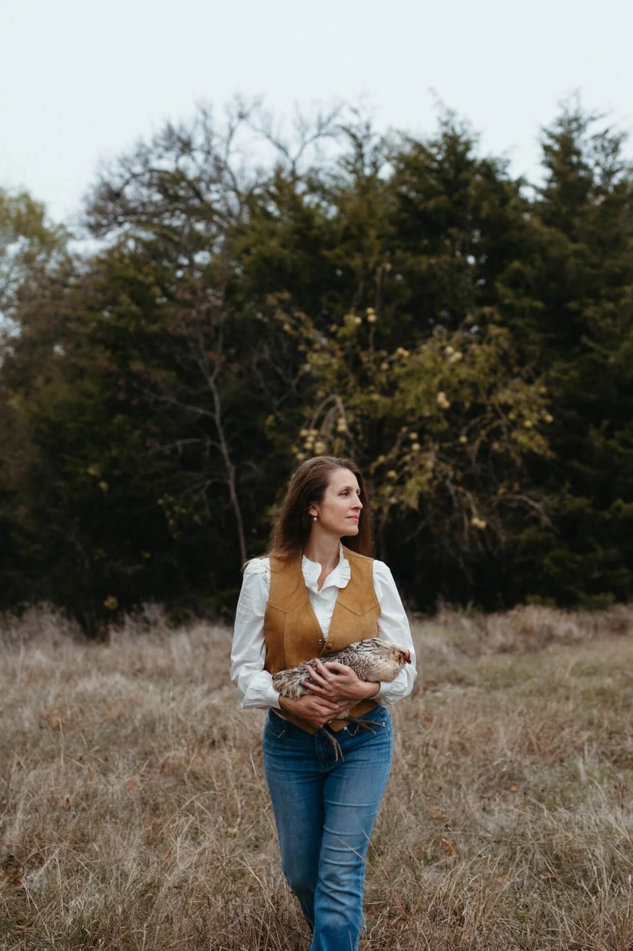 woman holds chicken on texas farm
