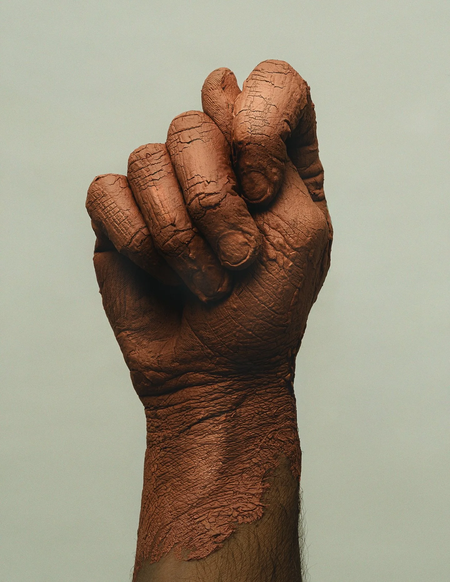 In this work, the figa appears enlarged, almost monumental.
The body covered in clay, cracked, dry, vulnerable.
Clay doesn&rsquo;t hide marks.
When water is missing, it breaks.
And in those fissures, it creates unique forms.

It doesn&rsquo;t promise