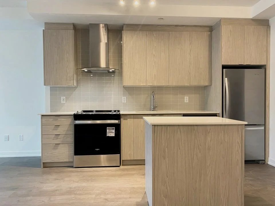 Modern kitchen with wooden cabinets, stainless steel appliances, and center island.