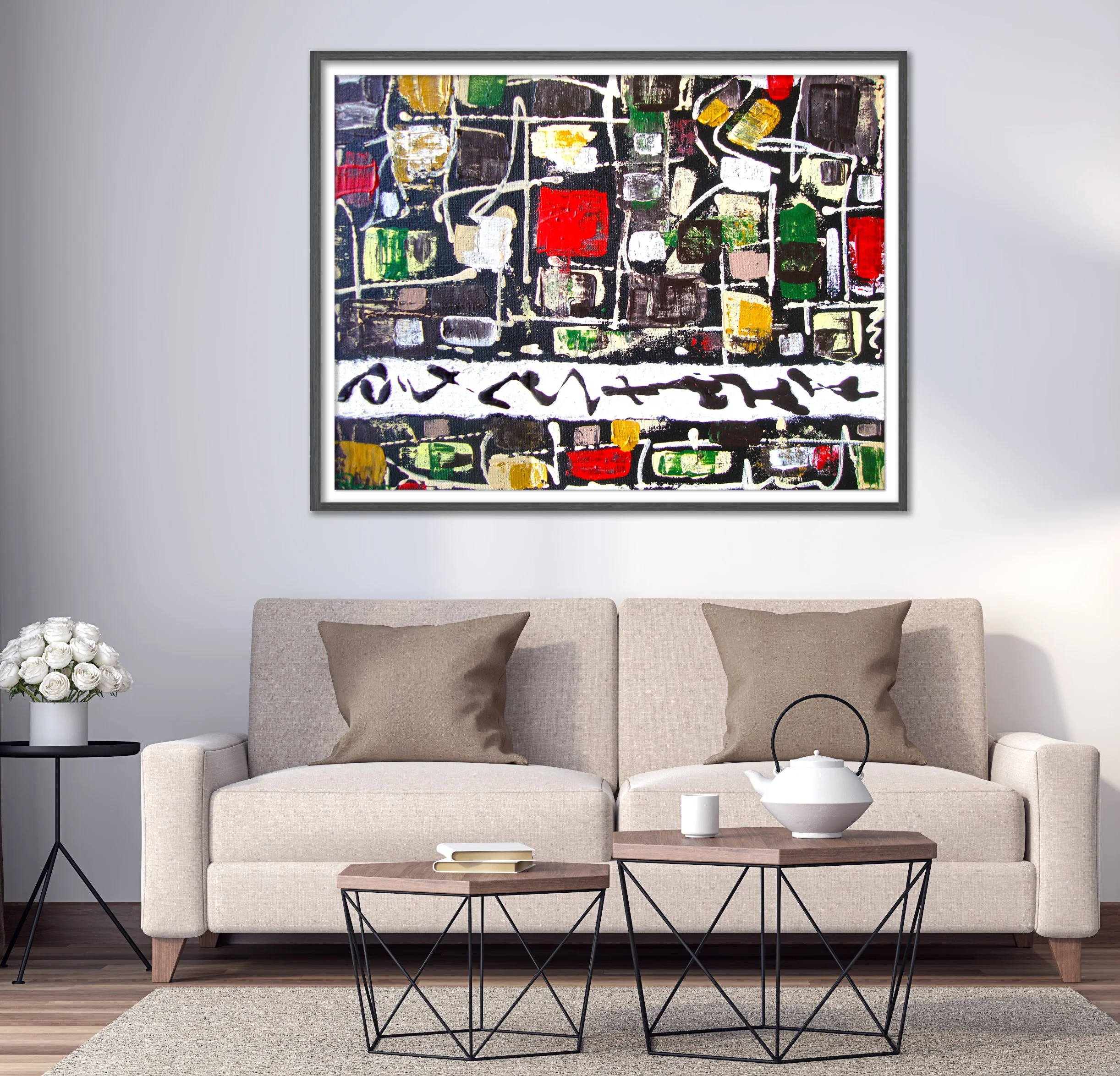 An abstract colorful painting hangs above a beige sofa with two beige pillows, in a modern living room. A small black side table with white roses, and a wooden coffee table with a teapot and cup are in front of the sofa.