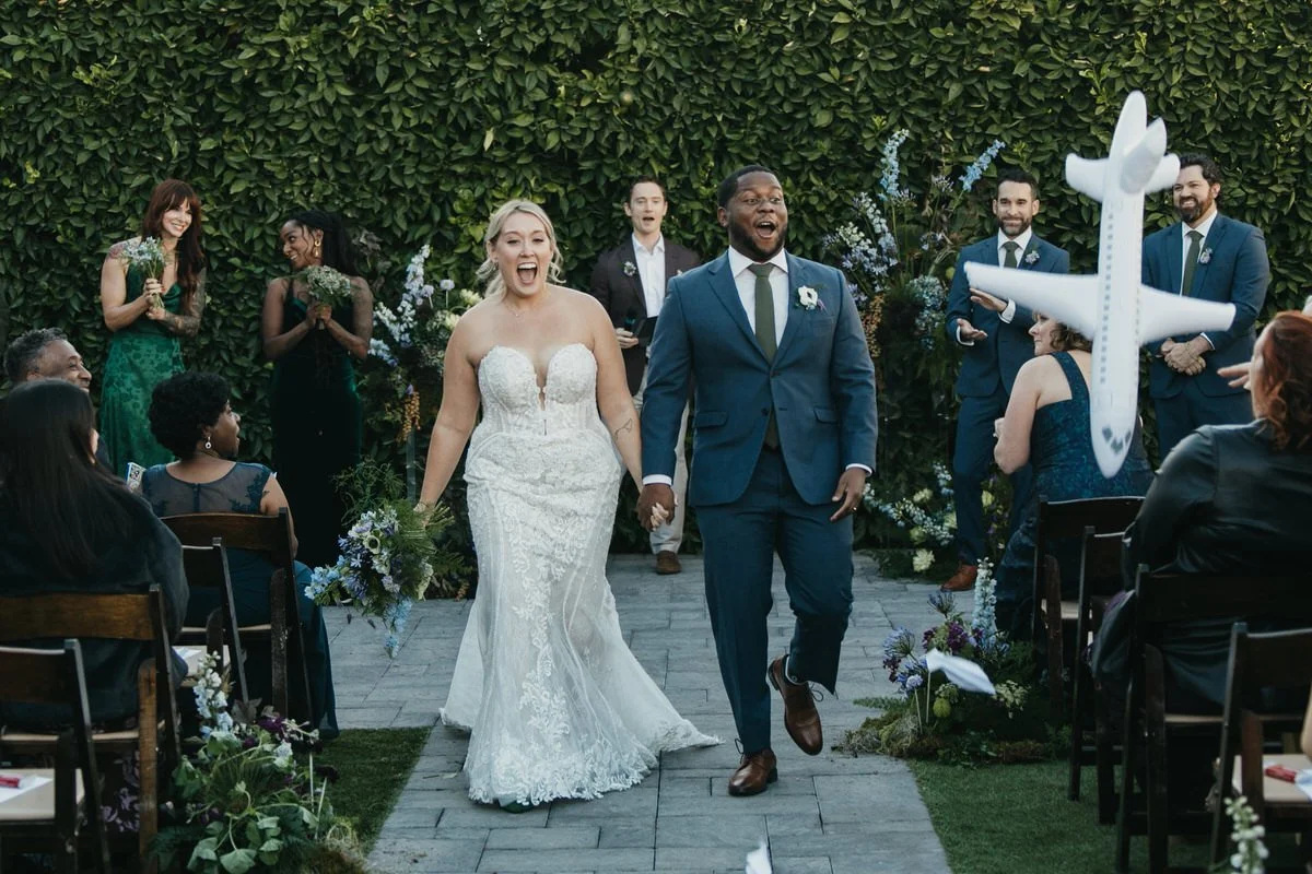 a bride and groom run through a tunnel of flashing light sticks at the end of their wedding day