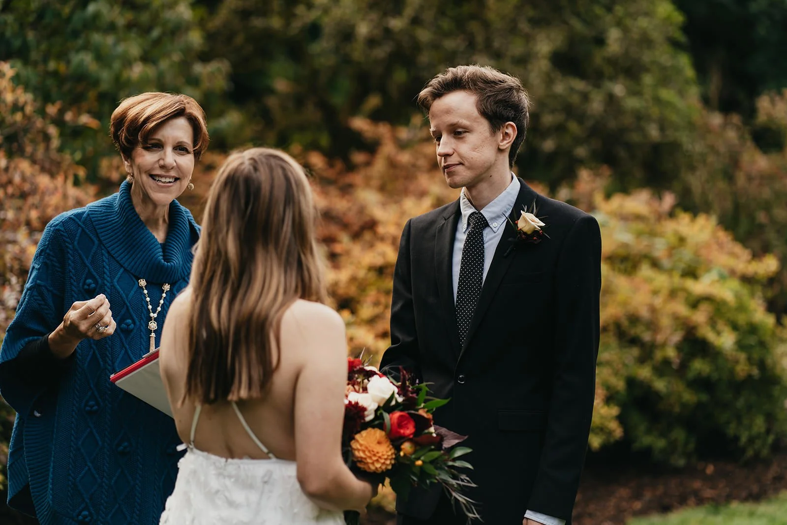 a bride and groom run through a tunnel of flashing light sticks at the end of their wedding day