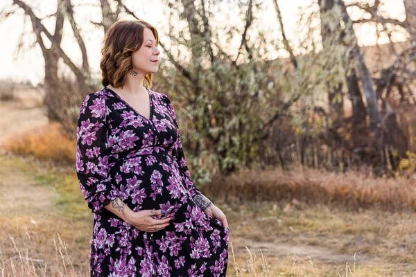 Pregnant woman cups her belly and closes her eyes as she smiles in Great Falls, MT maternity photo session
