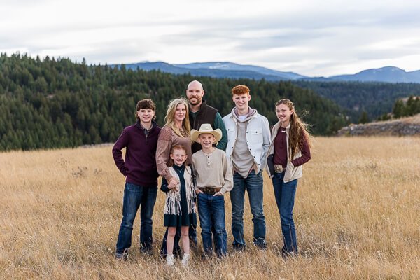 Family of 7 poses in front of mountain background
