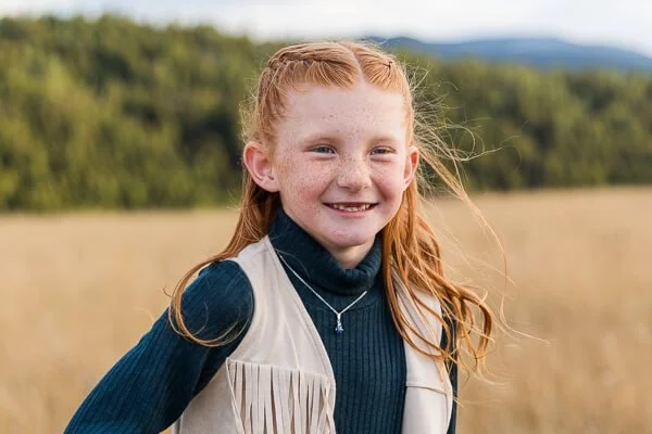 Little girl smiles and gazes off into the distance