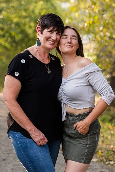 Mom and teenage daughter snuggle against each other