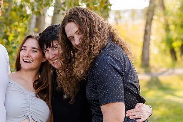 Mom peeks out from between teen son & daughter