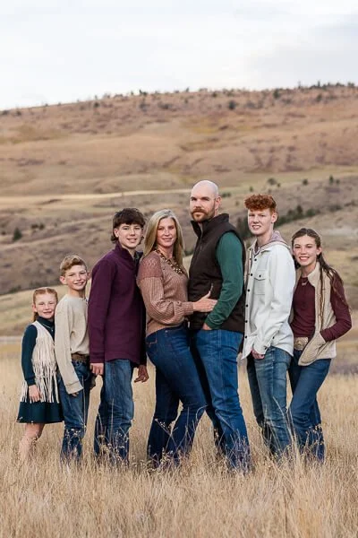 Family of seven leans into each other and smiles