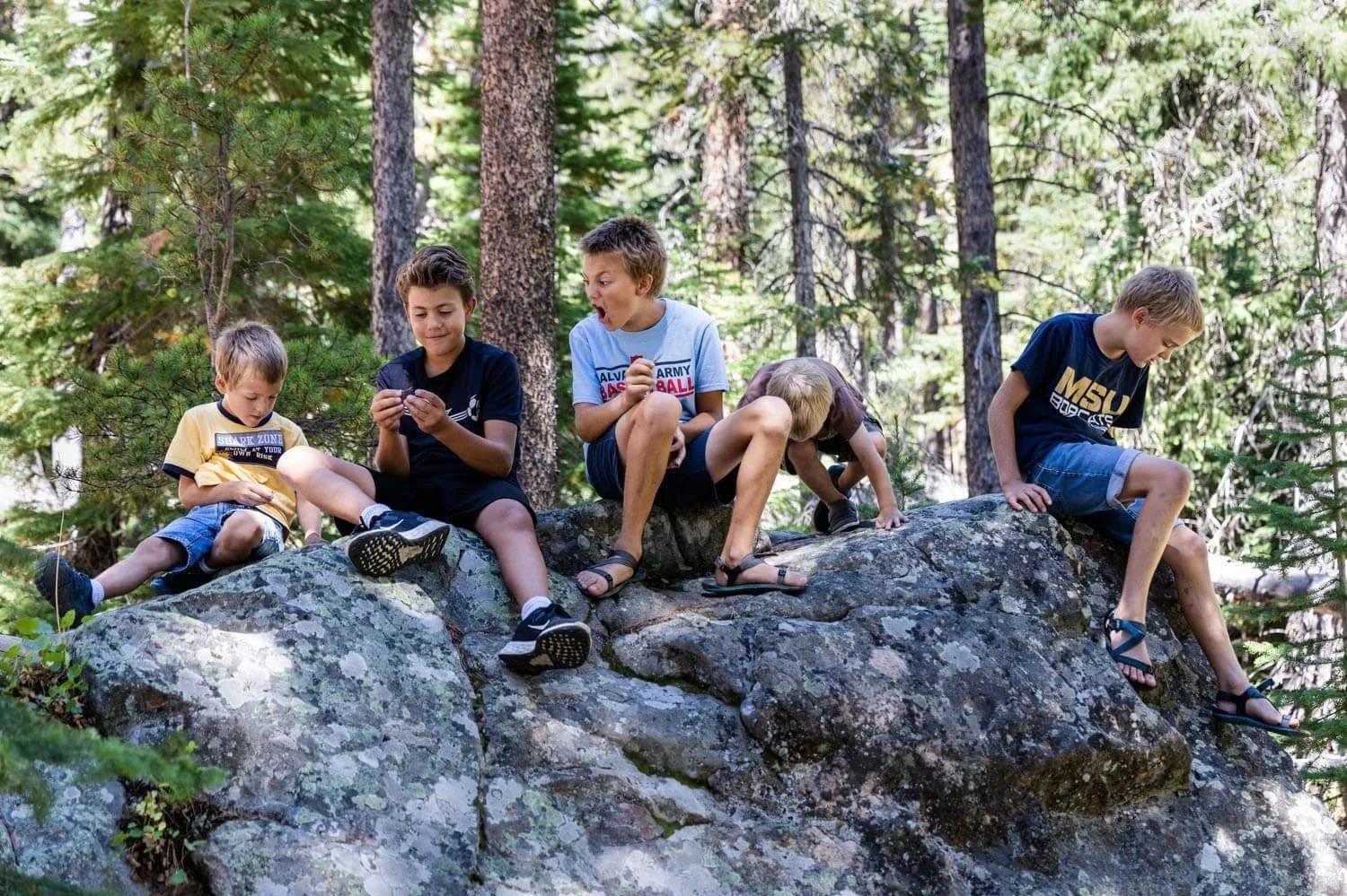 Five boys sitting on a rock forest ledge in Great Falls, MT