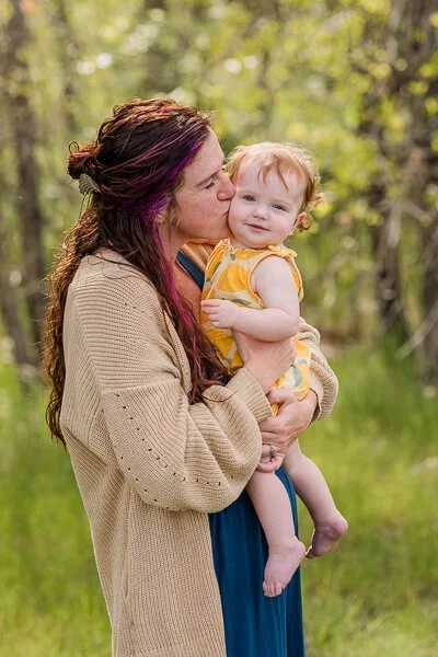 Mom kisses toddler daughter's cheek