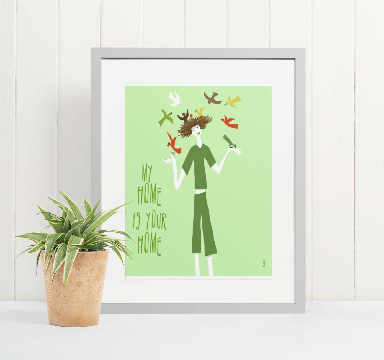 a-picture-frame of a print %22My Home Is Your Home%22 -next-to-a-plant.jpg
