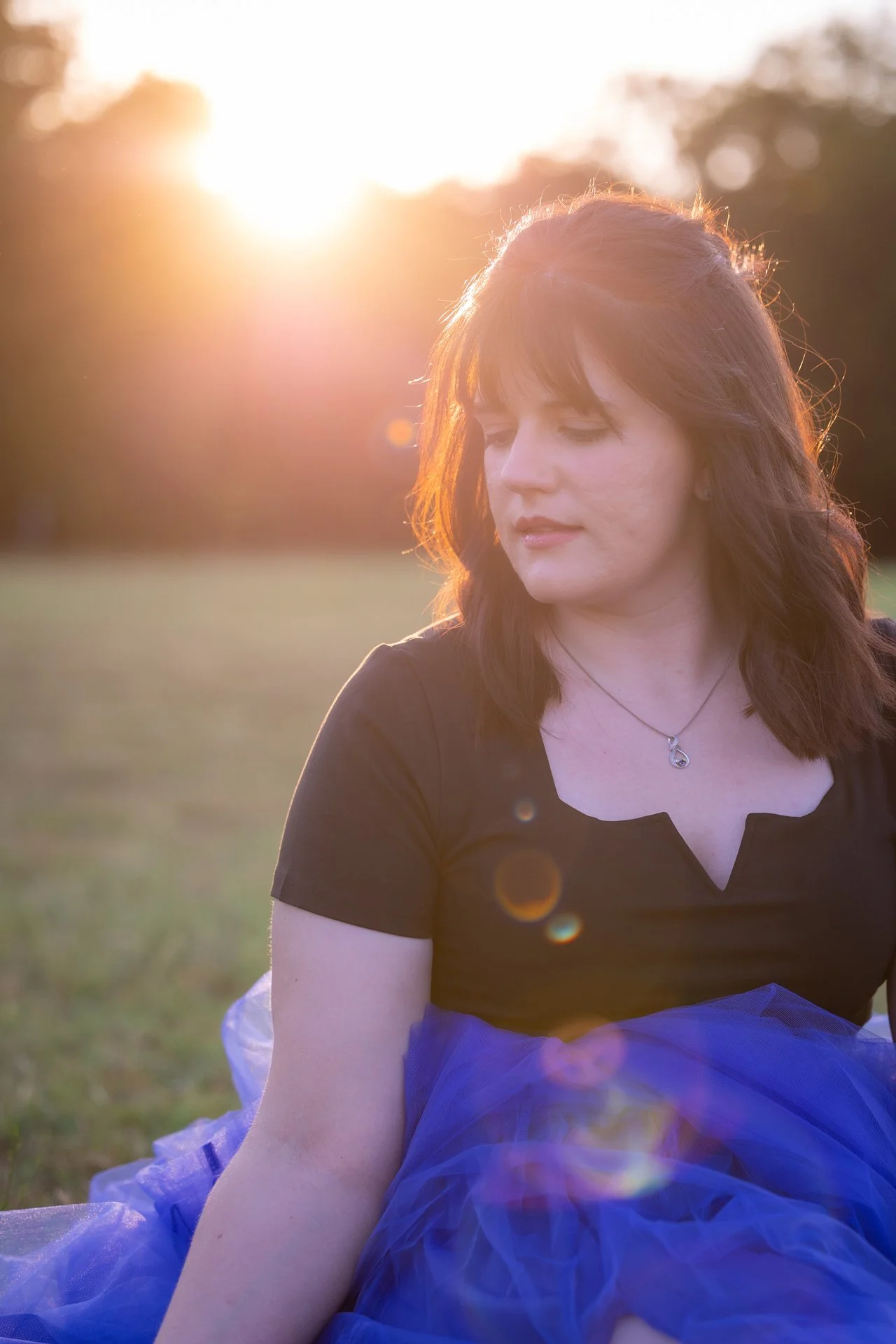 Woman gazing at ground at sunset