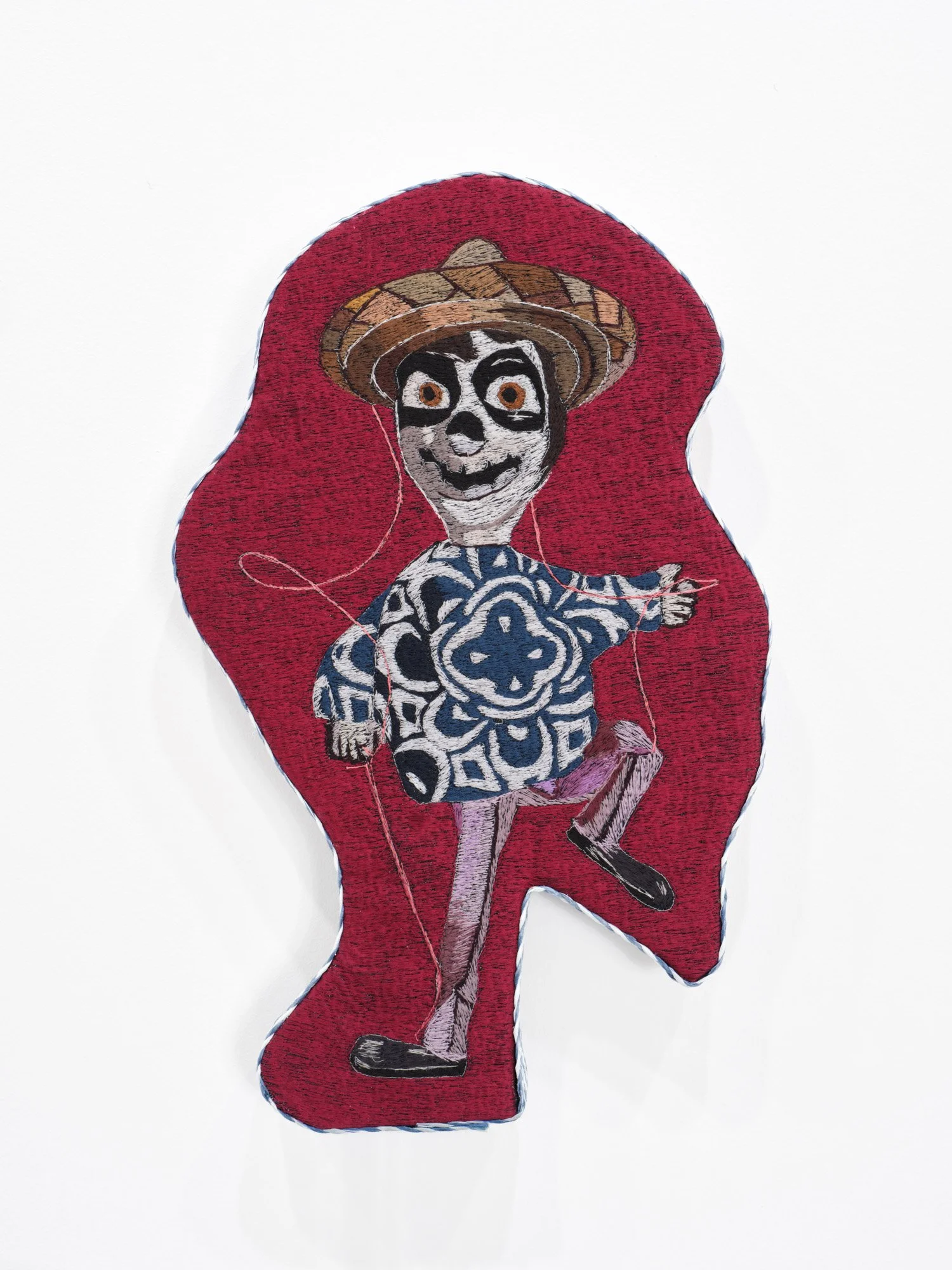 Erick Medel 
Coco Loco, 2026 
Polyester thread on denim, shaped panel, straw ribbon 
13 x 20.5 inches