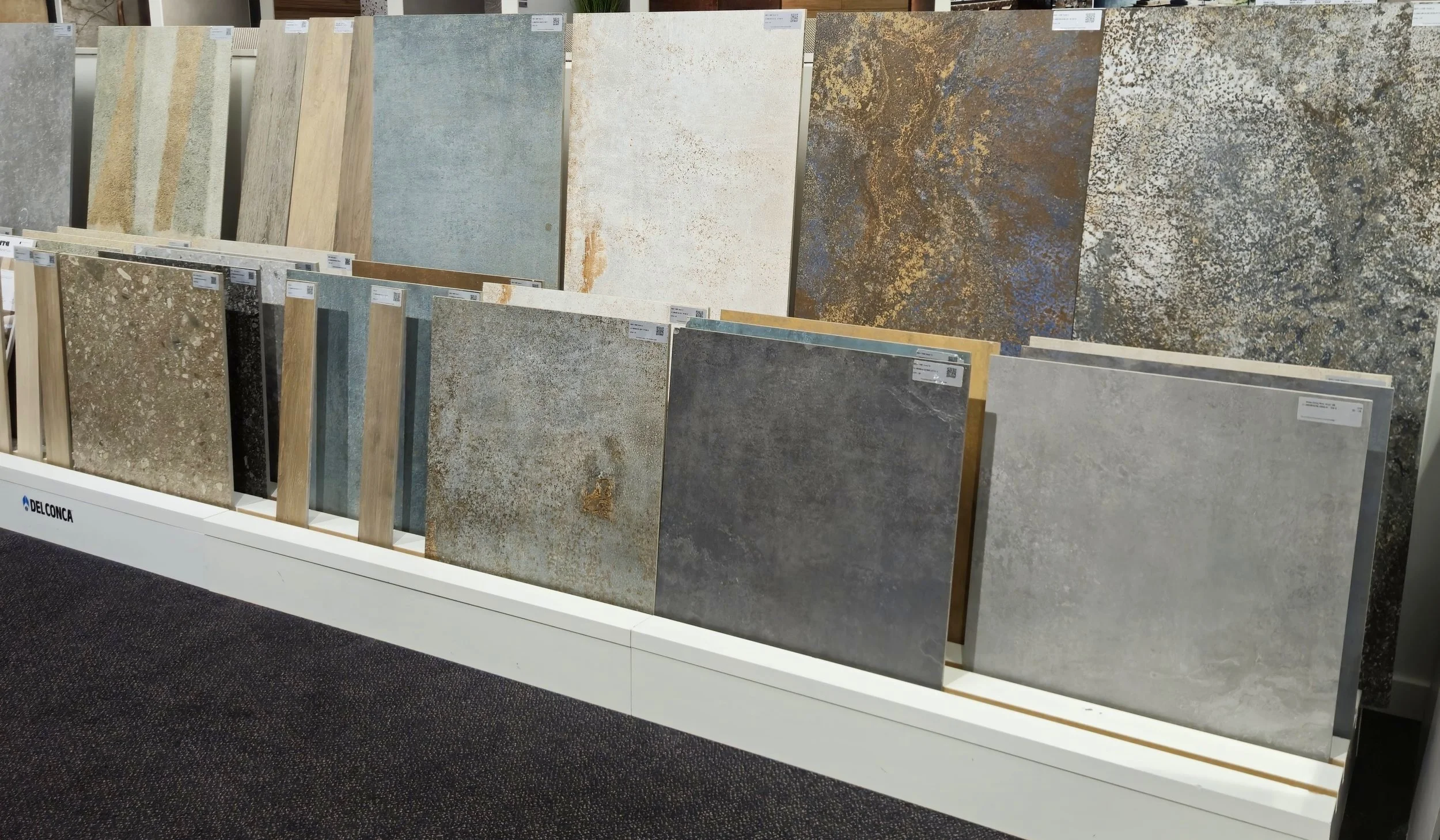 Diverse keramische vloer- en wandtegels op display in een showroom.