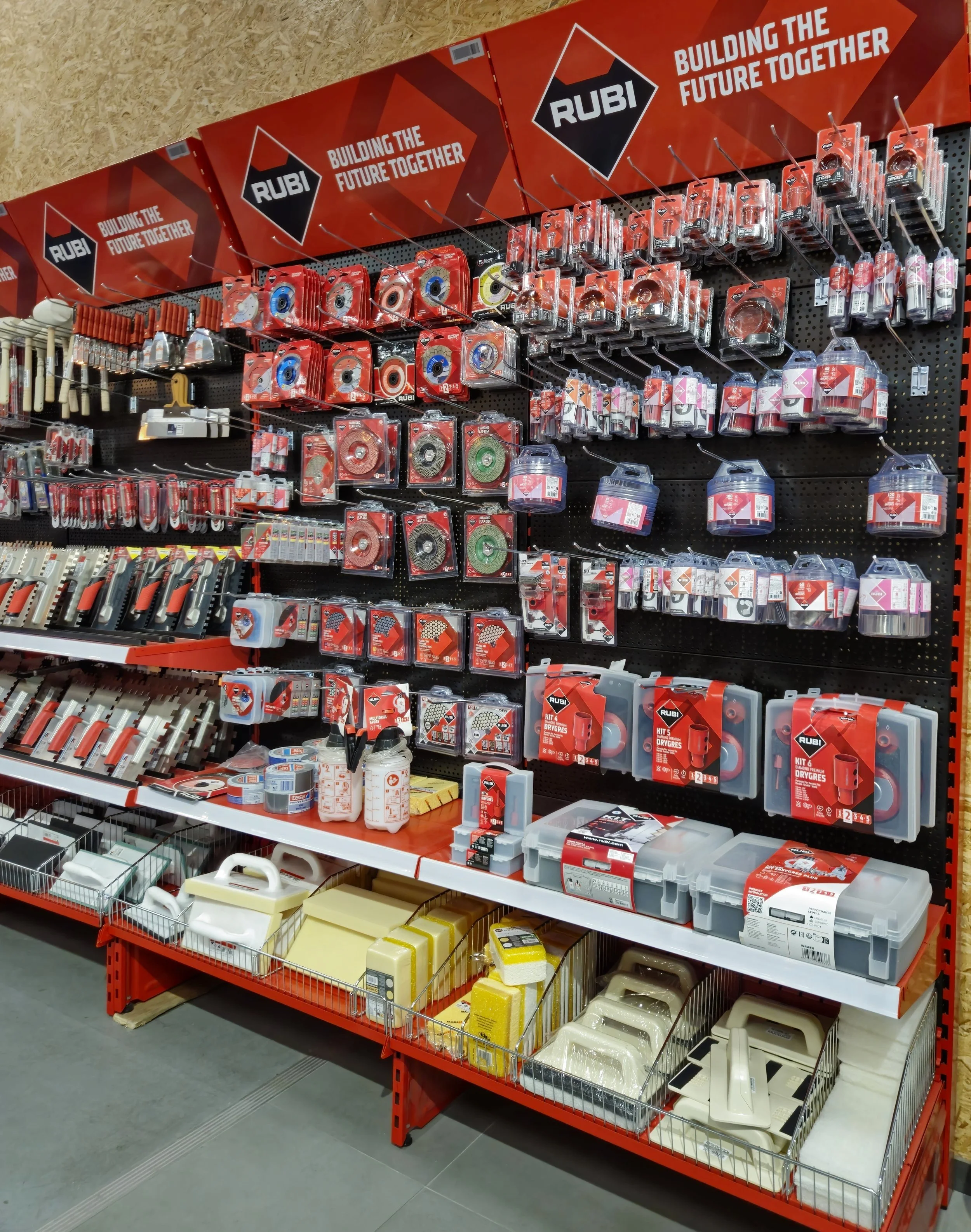 Winkelrek met tegelgereedschap, inclusief tegelsnijschijven, troffels, sponsen en andere bouwbenodigdheden.