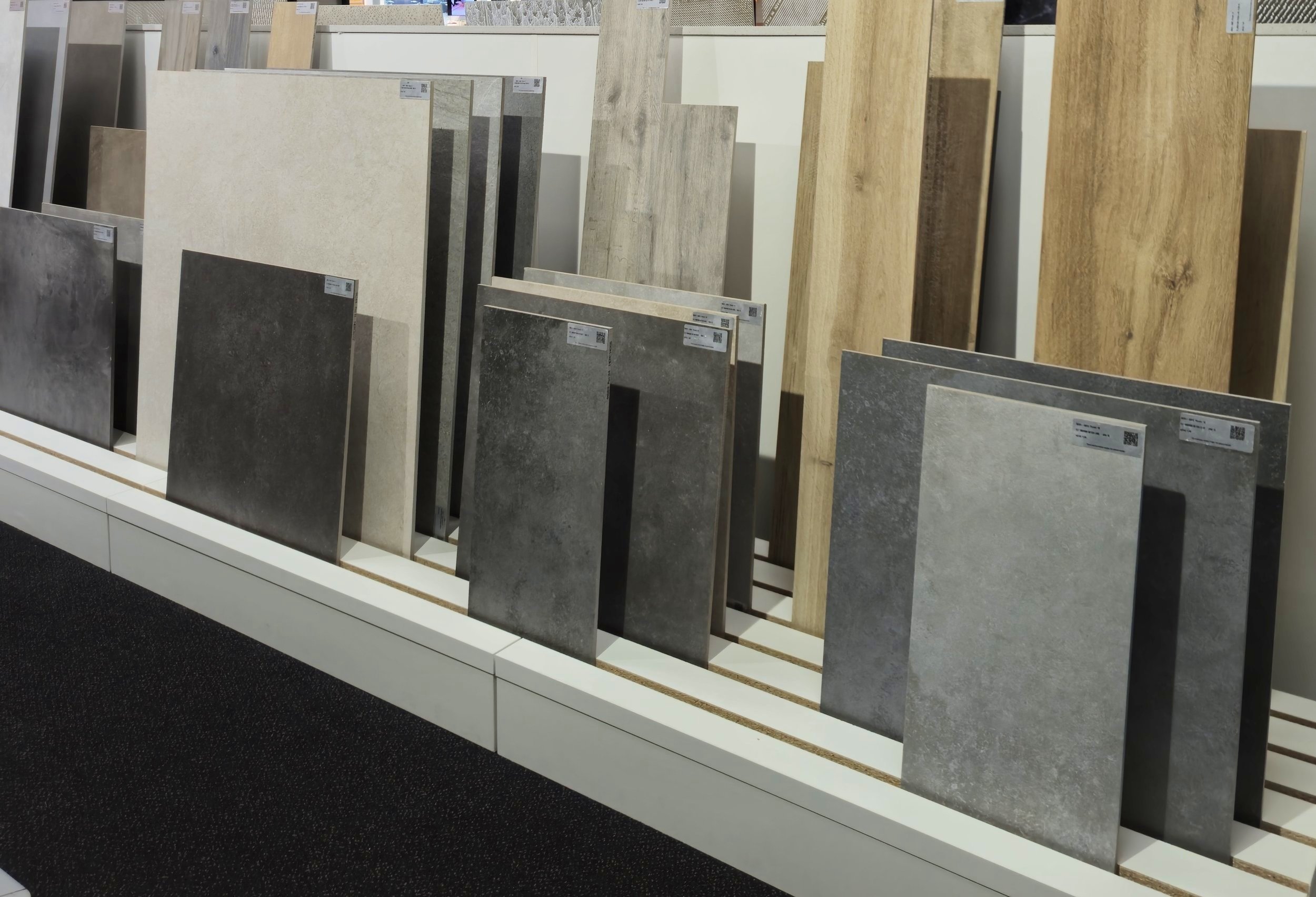 Verschillende kleur- en textuurtegels op een display in een showroom.