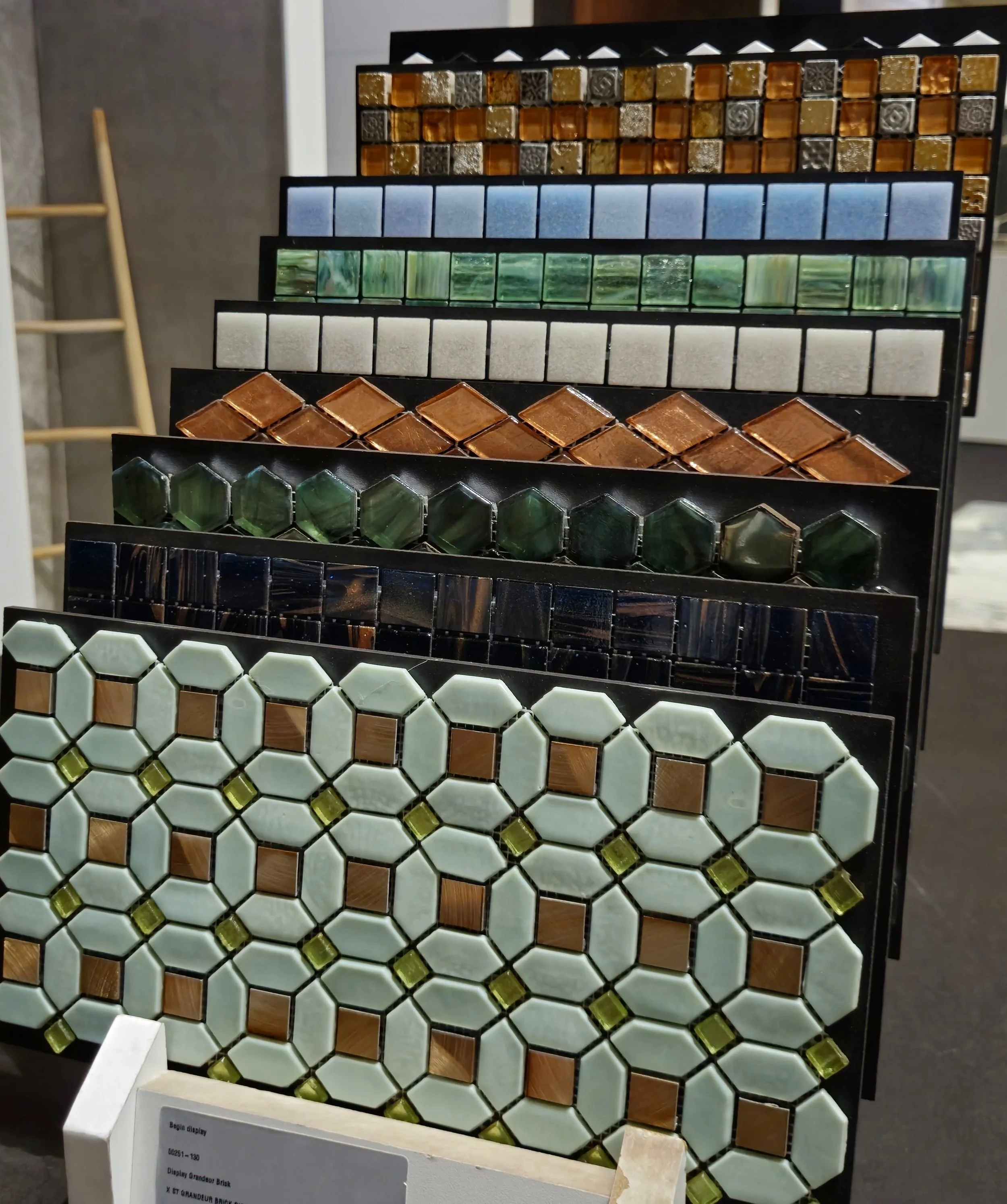 Gekleurde mozaïektegelmonsters in verschillende patronen en texturen tentoongesteld op panelen.