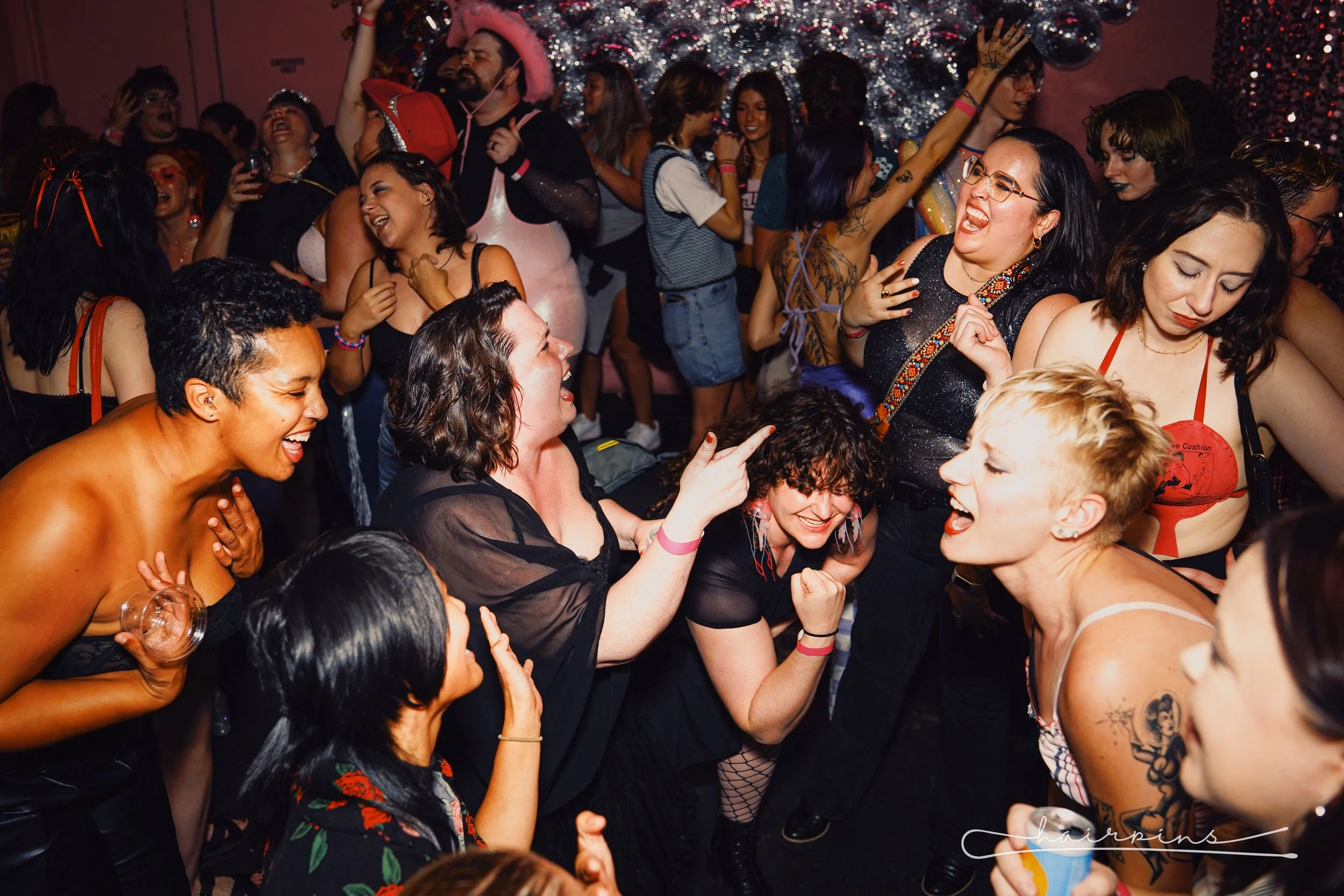 People dancing and having fun at a lively party with colorful outfits and decorations.