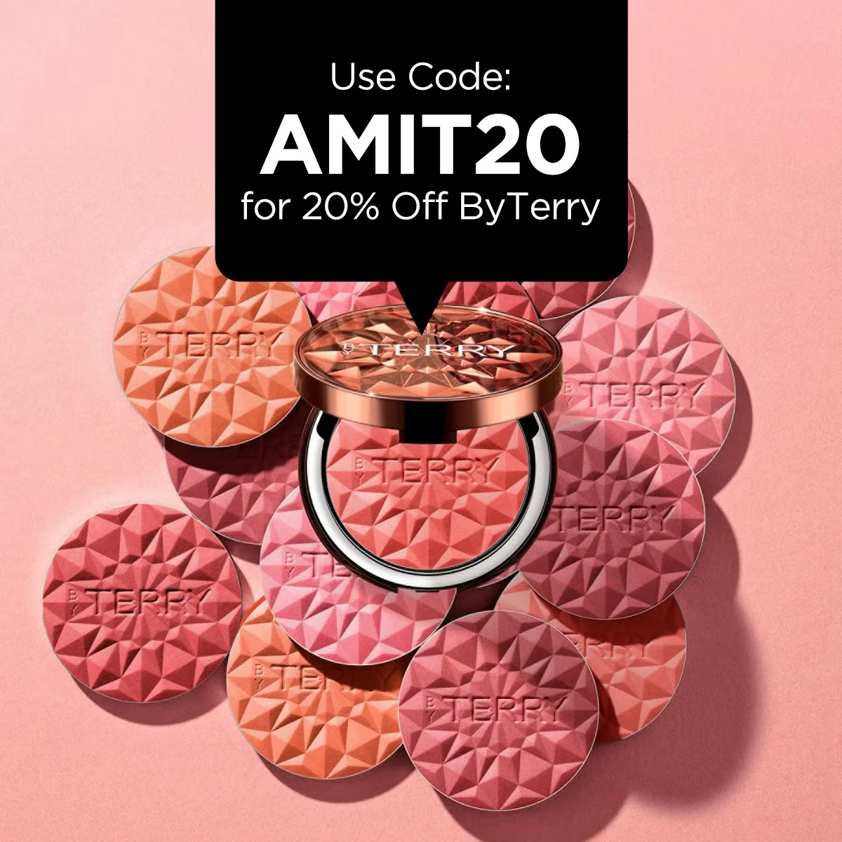 Pink background with a collection of round blush or makeup compacts with geometric patterns and the brand name 'Terry' embossed on each. One compact is open, revealing peach-colored blush inside, with the lid reflecting the geometric pattern above it. Text at the top reads 'Use My By Terry Code: AMIT20' and at the bottom, 'For 20% Off Everytime You Shop.'