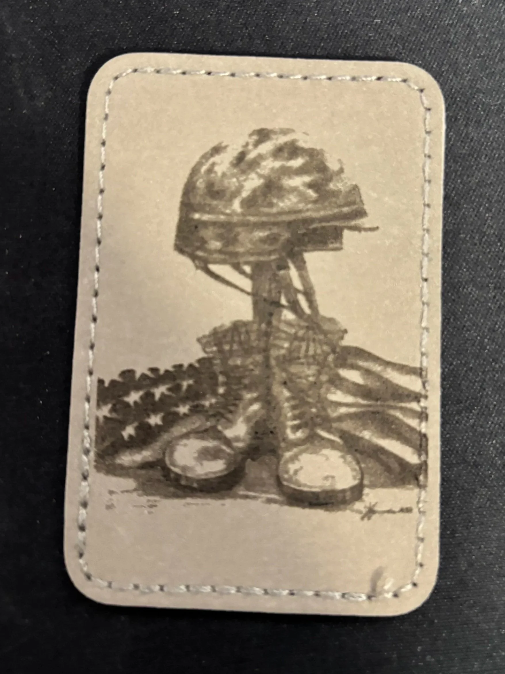 Black and white illustration of a soldier helmet with the American flag and military boots underneath.