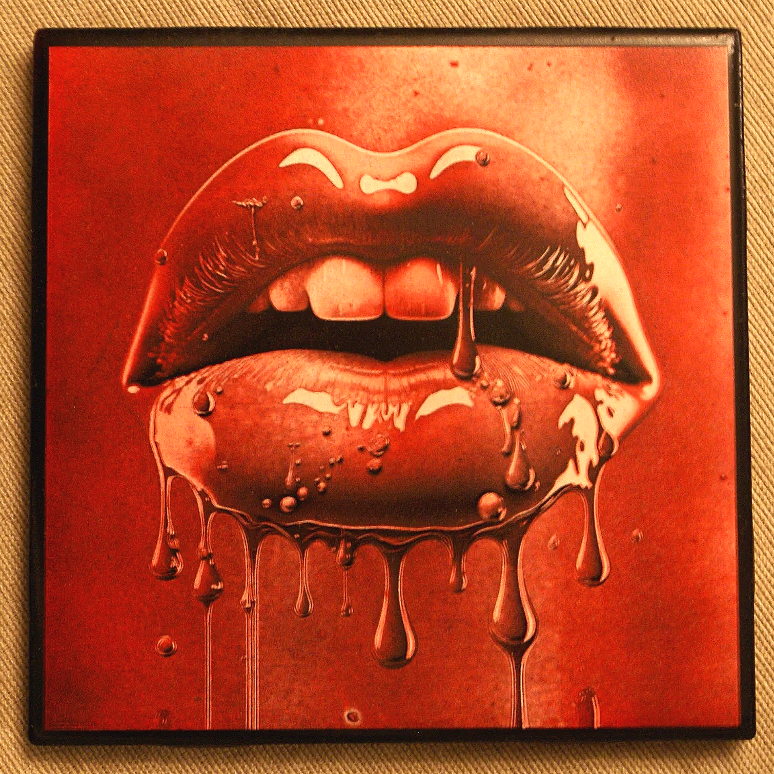 Close-up of lips with melting chocolate dripping down, against a reddish background.