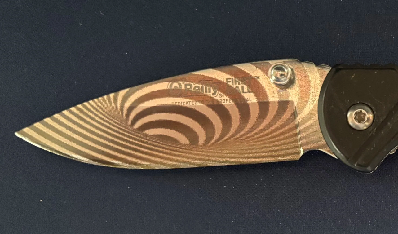 A folding pocket knife with a laminated wood handle and a stainless steel blade, open and placed on a dark surface.