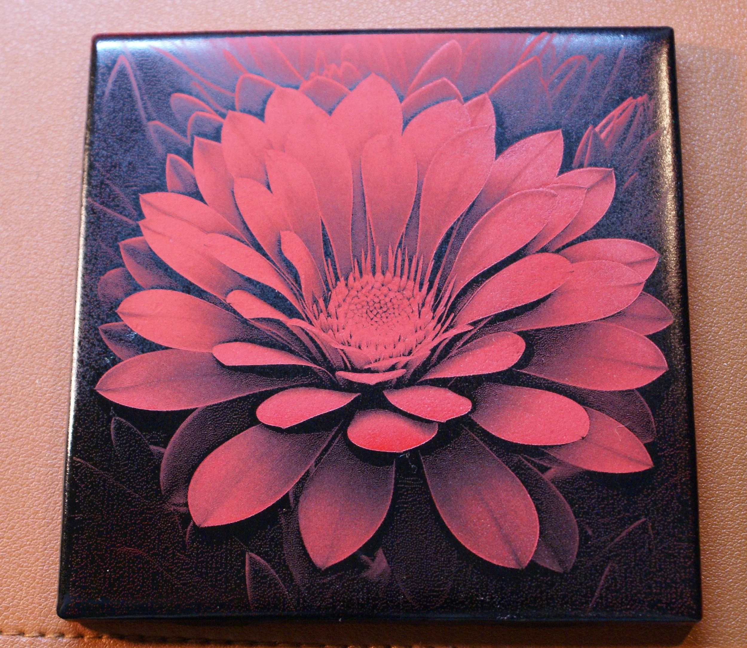 A square canvas with a stylized red and black flower illustration with layered petals.